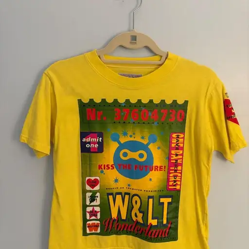 Yellow cropped t-shirt with graphic featuring 'W&LT Wonderland', 'KISS THE FUTURE!', and 'admit one' text #wonderland #graphic