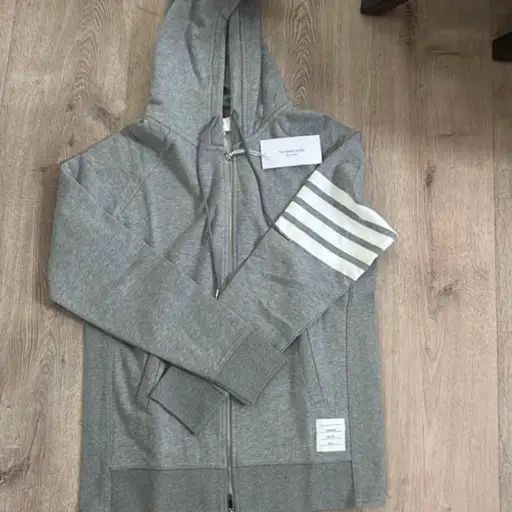 Thom Browne gray zip up hoodie with white stripes on the sleeve #thombrowne #luxury